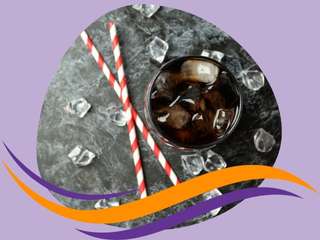 A photo of two straws and a glass of dark soda with ice